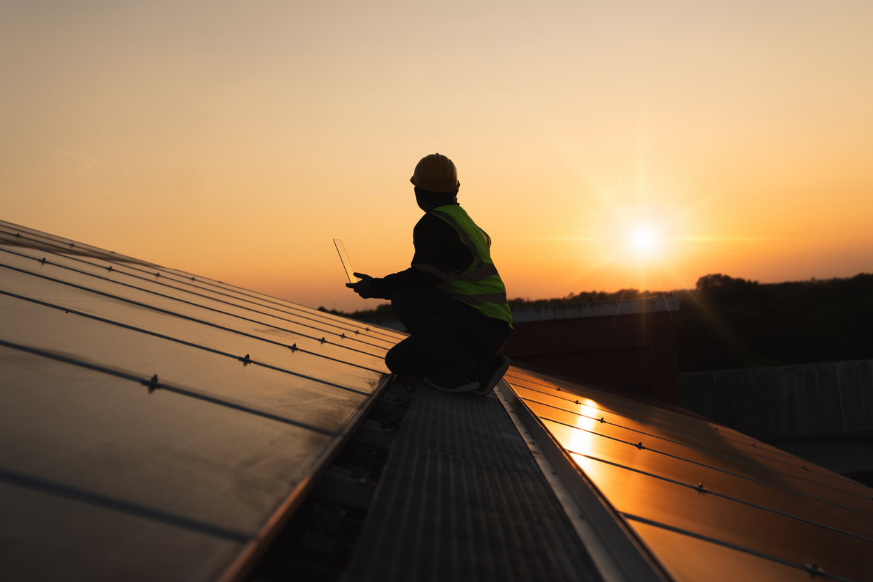 Electrician examining solar panels to reduce electrical problems and improve energy efficiency in Burlington, WA.