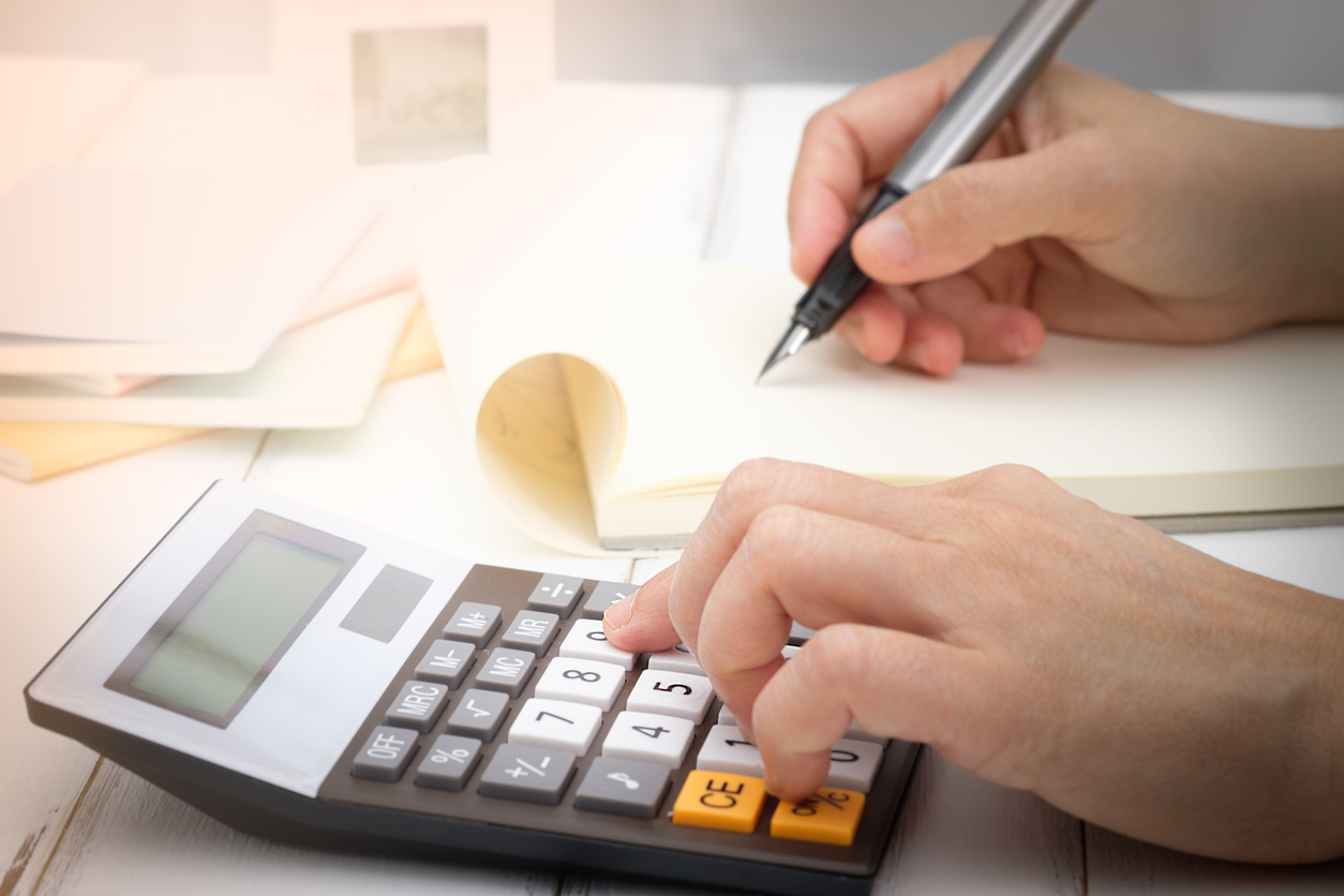 Person using a calculator to compare solar energy rebates and net metering savings in Washington.