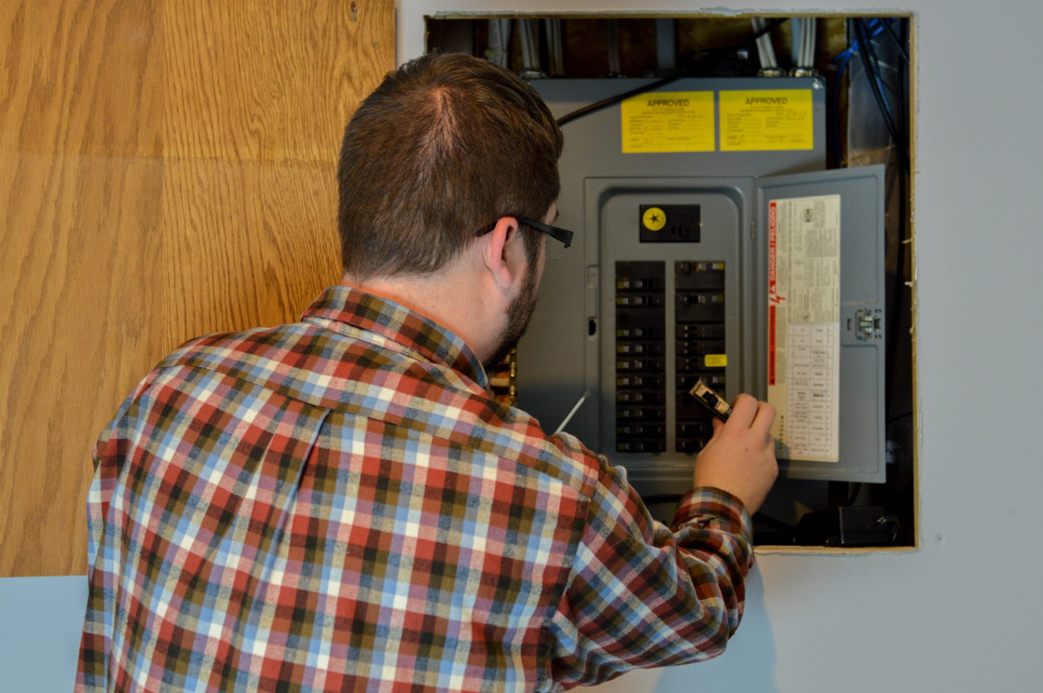 A man trying to fix a tripped circuit breaker in his Burlington, WA, home.